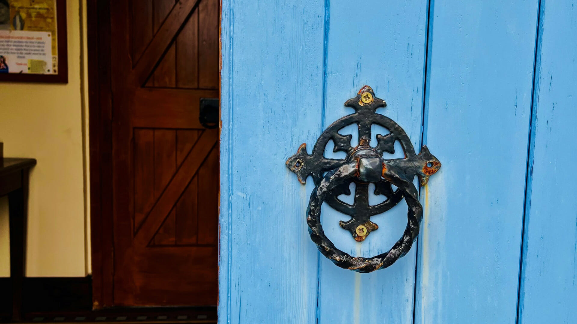 Blue church door with black circle drop handle